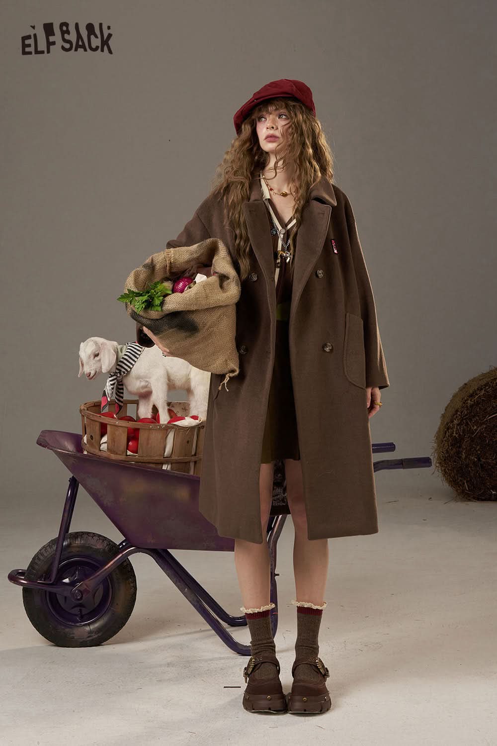 Fashionable model in a brown coat holding a bag of vegetables and wearing a plaid knit sweater for women