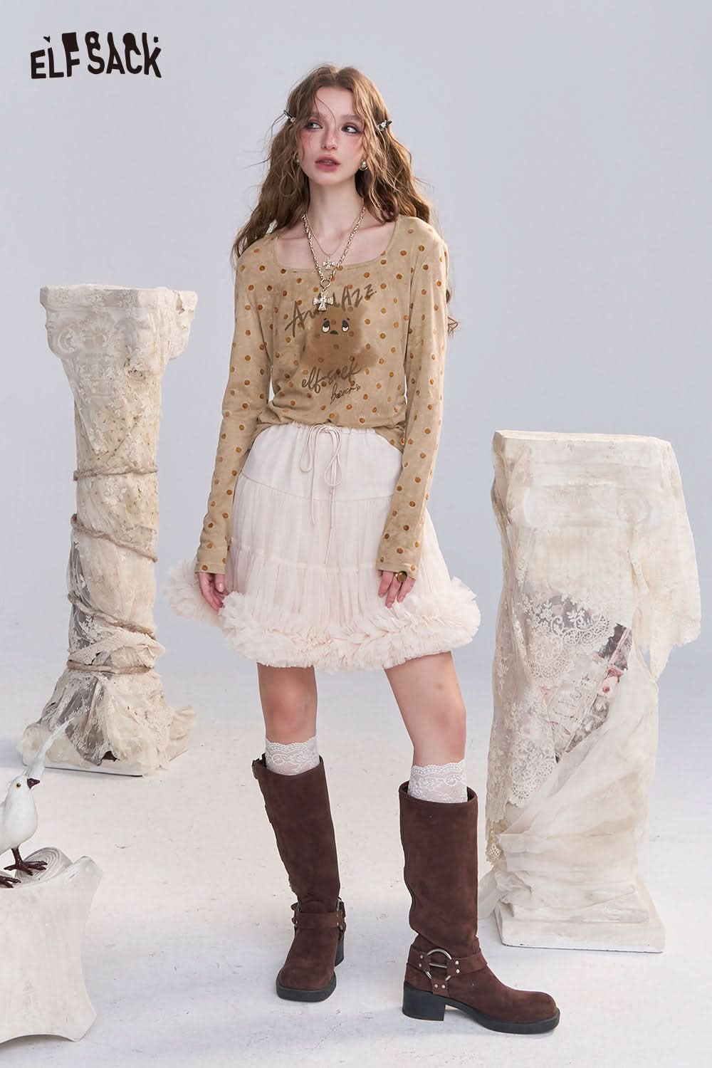 ELFSACK playful graphic print tee for women styled with a ruffled skirt and knee-high boots