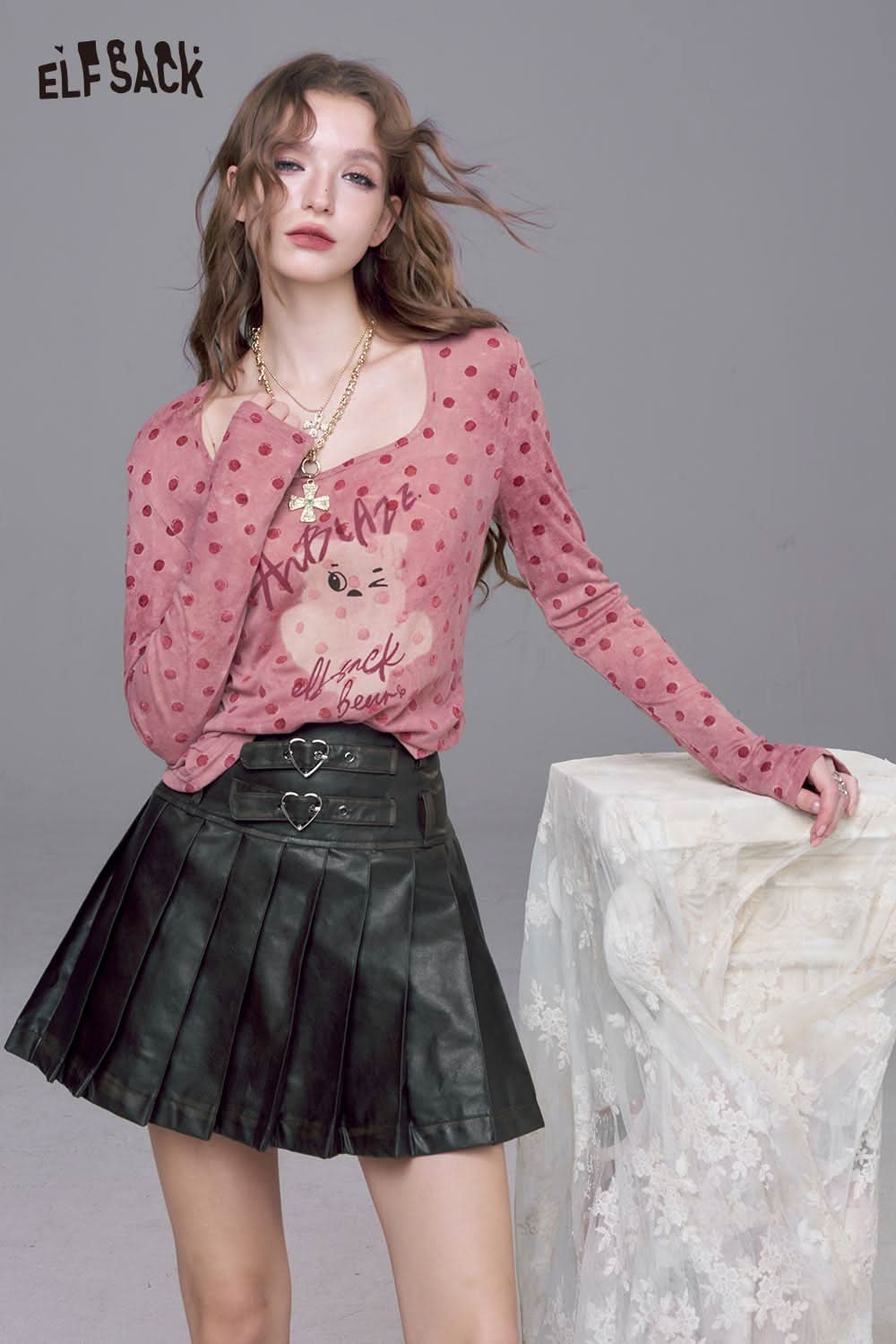 ELFSACK playful graphic print tee for women in pink with polka dots, styled with a black pleated skirt