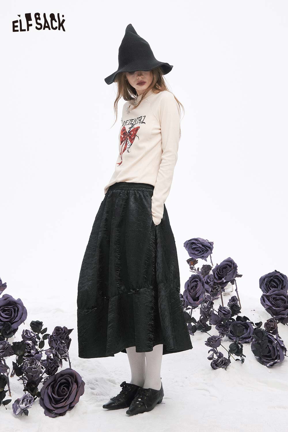 ELFSACK pleated A-line long skirt in black paired with a trendy top and hat