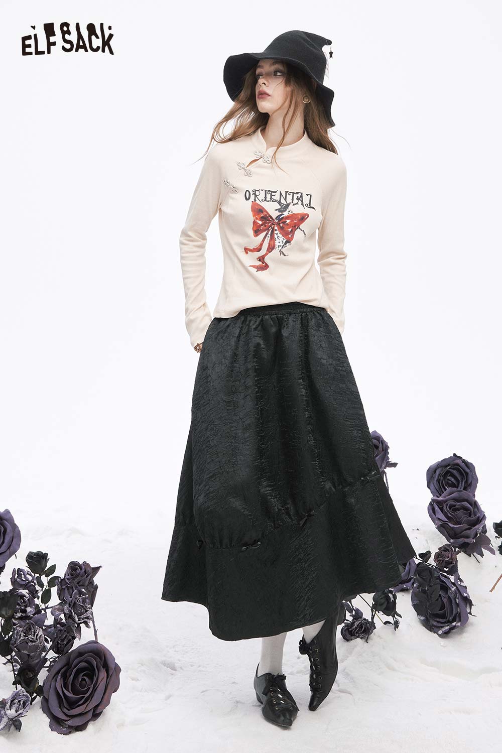 ELFSACK pleated A-line long skirt in black paired with a graphic top and stylish accessories