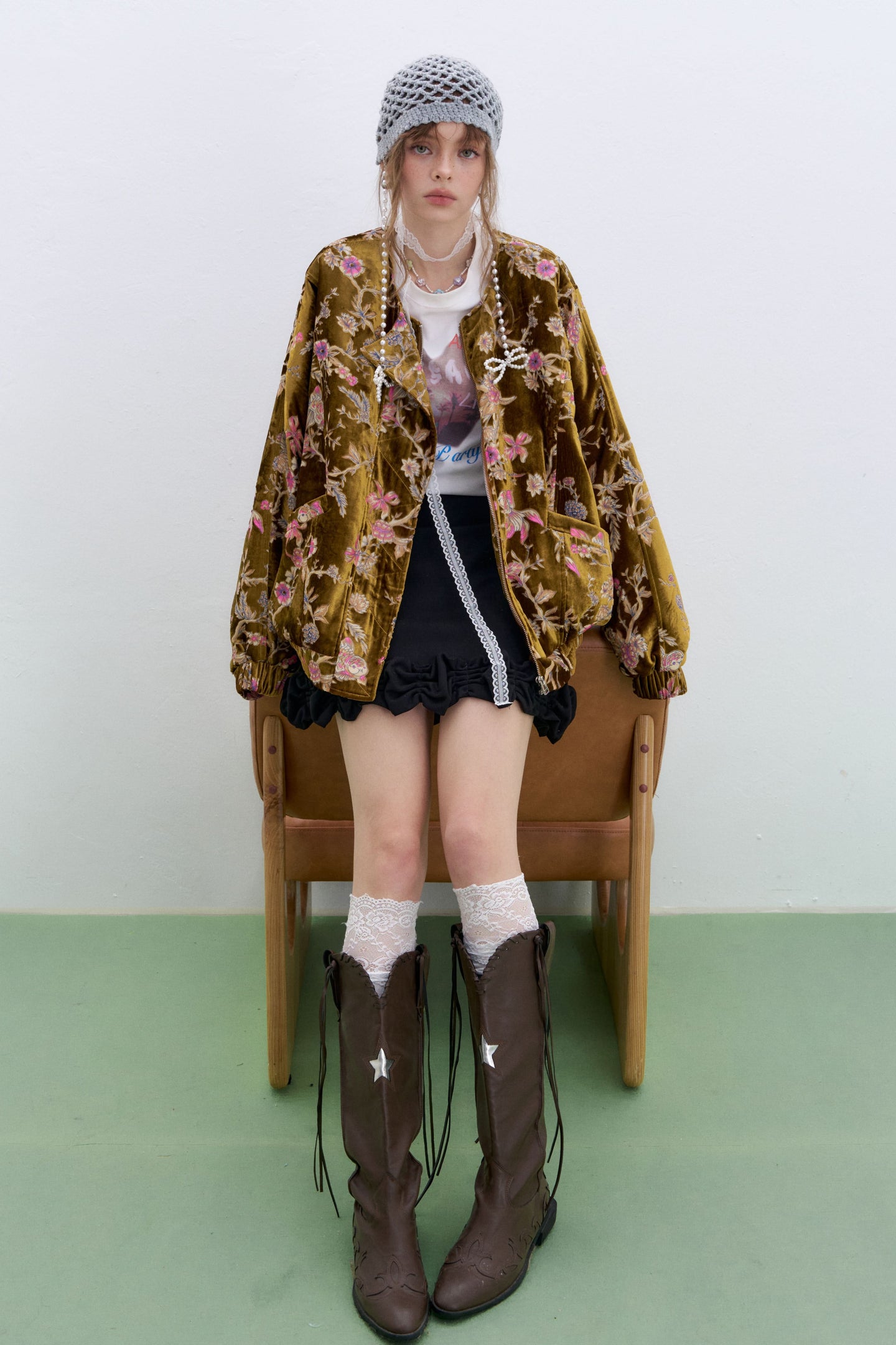 Model wearing a plus size floral velvet bomber jacket with intricate floral details and oversized fit