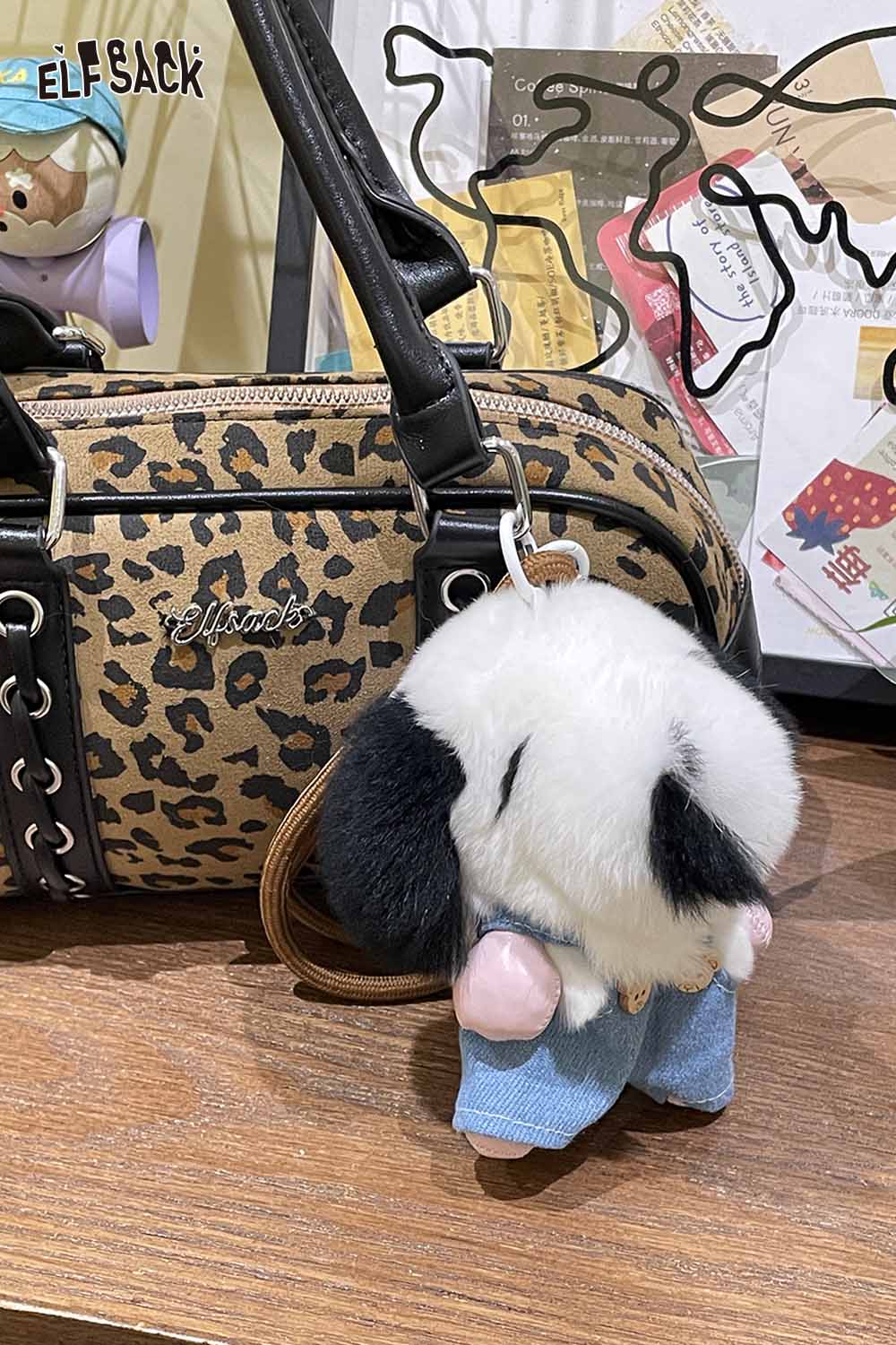 ELFSACK plush animal keychain attached to a stylish leopard print bag