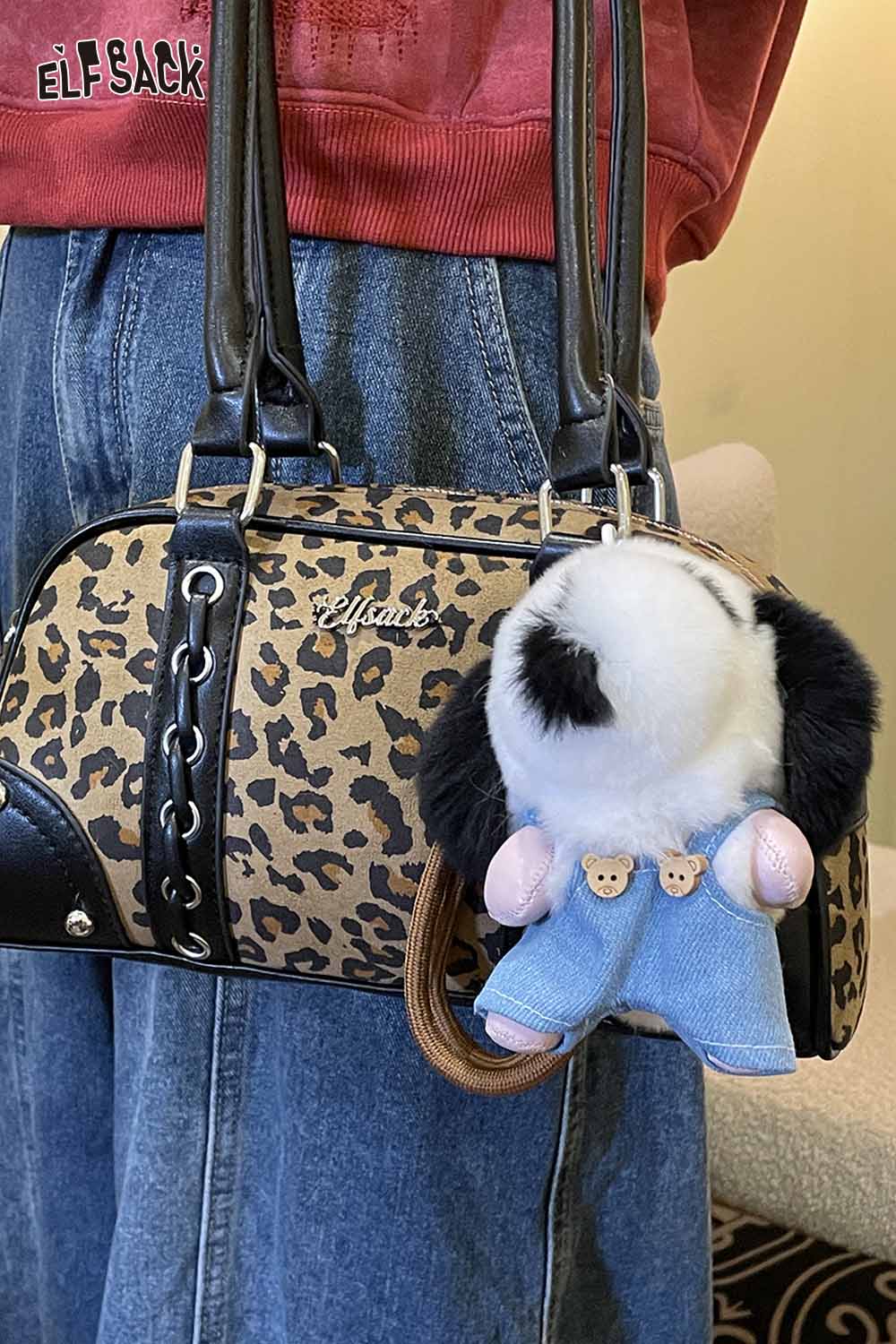 ELFSACK plush animal keychain in denim outfit attached to a leopard print handbag