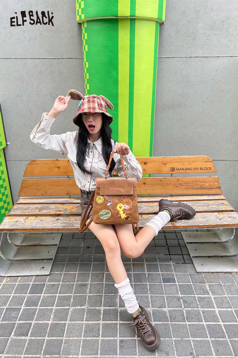 Fashionable ELFSACK plush ear tartan bucket hat paired with a stylish outfit and handbag