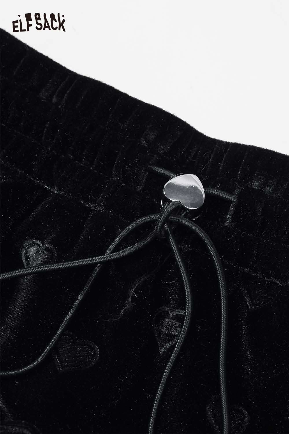 Close-up of ELFSACK preppy black velvet mini skirt featuring a heart-shaped drawstring detail