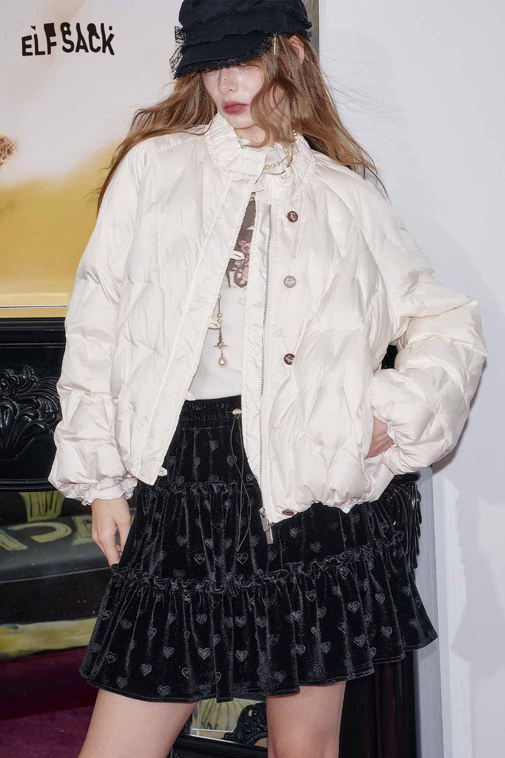 Fashionable model wearing a preppy black velvet mini skirt paired with a chic puffy jacket