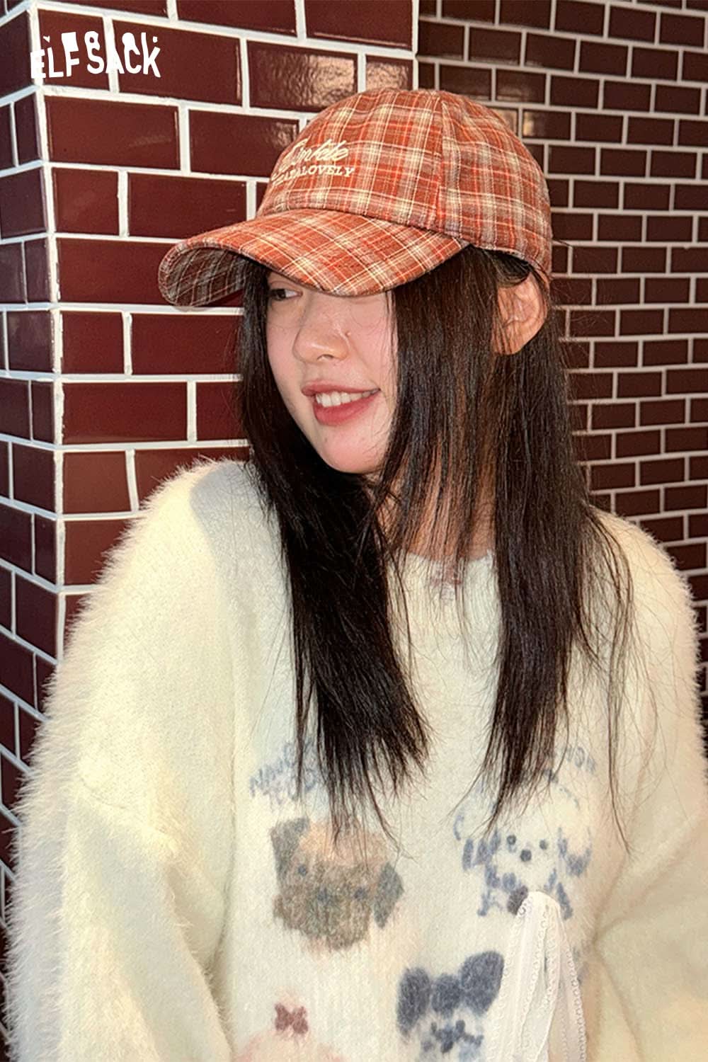 Stylish woman wearing a preppy plaid baseball cap for women with a cozy sweater