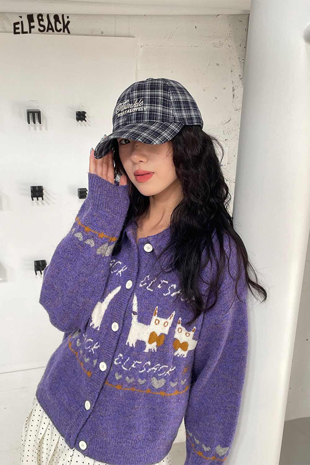 Stylish woman wearing a purple sweater and preppy plaid baseball cap for women, posing casually indoors