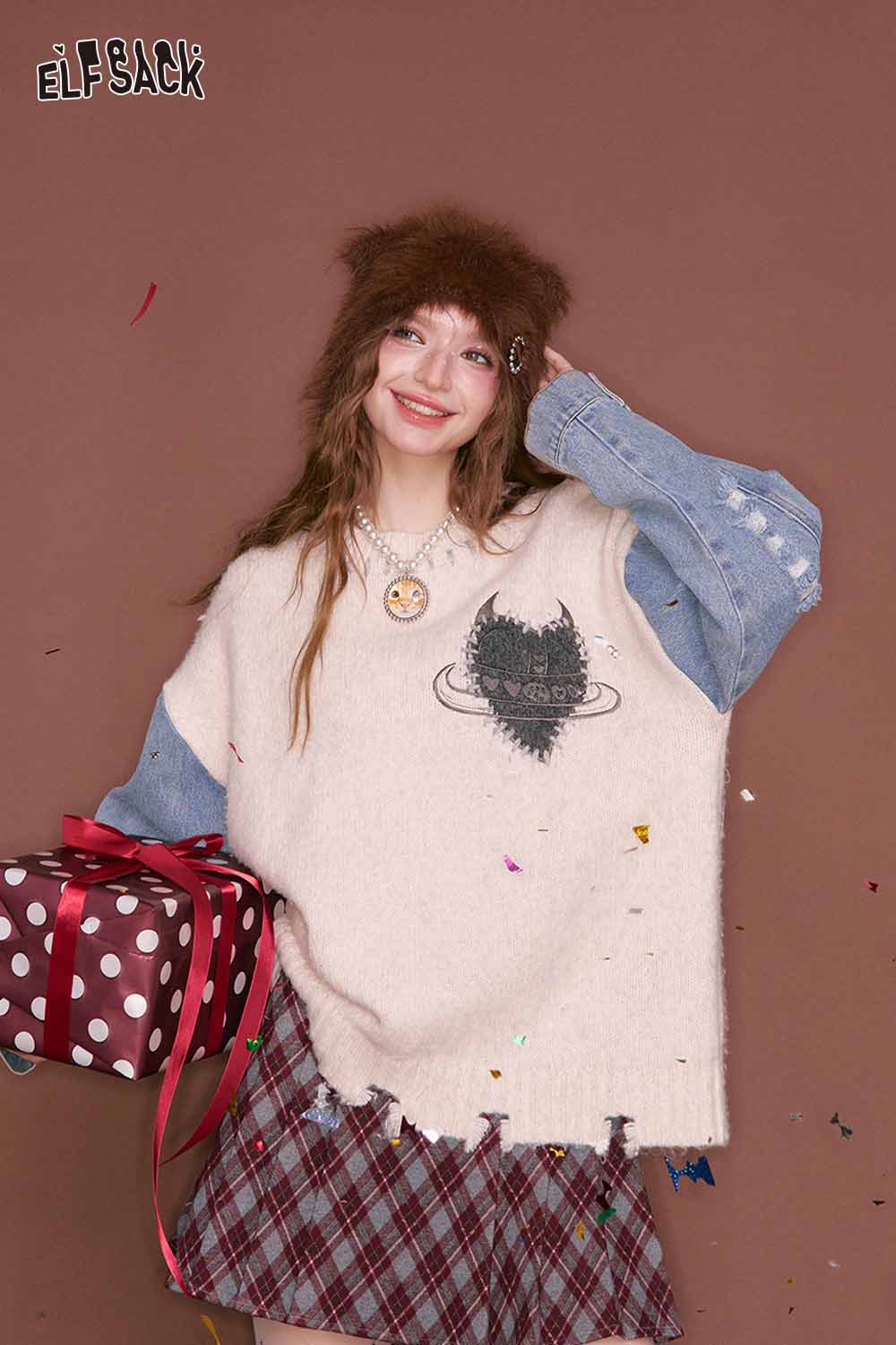 Model wearing a preppy plaid pleated short skirt styled with a cozy sweater and hat