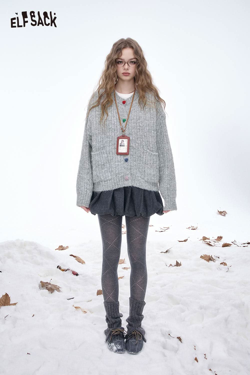 ELFSACK preppy round neck sweater in grey, styled with a layered skirt and cozy leggings