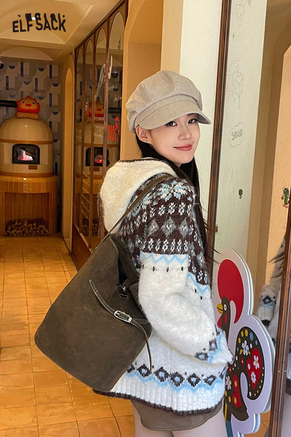 Stylish model showcasing a PU leather bucket bag for women with a cozy sweater and cap