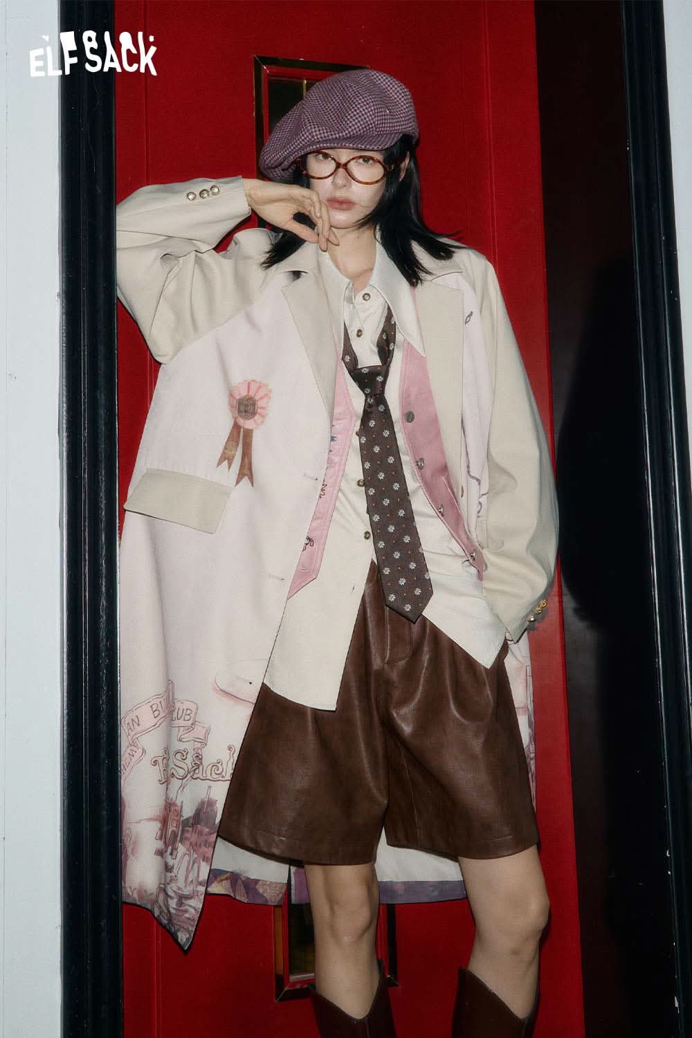 ELFSACK stylish model wearing PU leather pleated shorts with a chic oversized coat and accessories