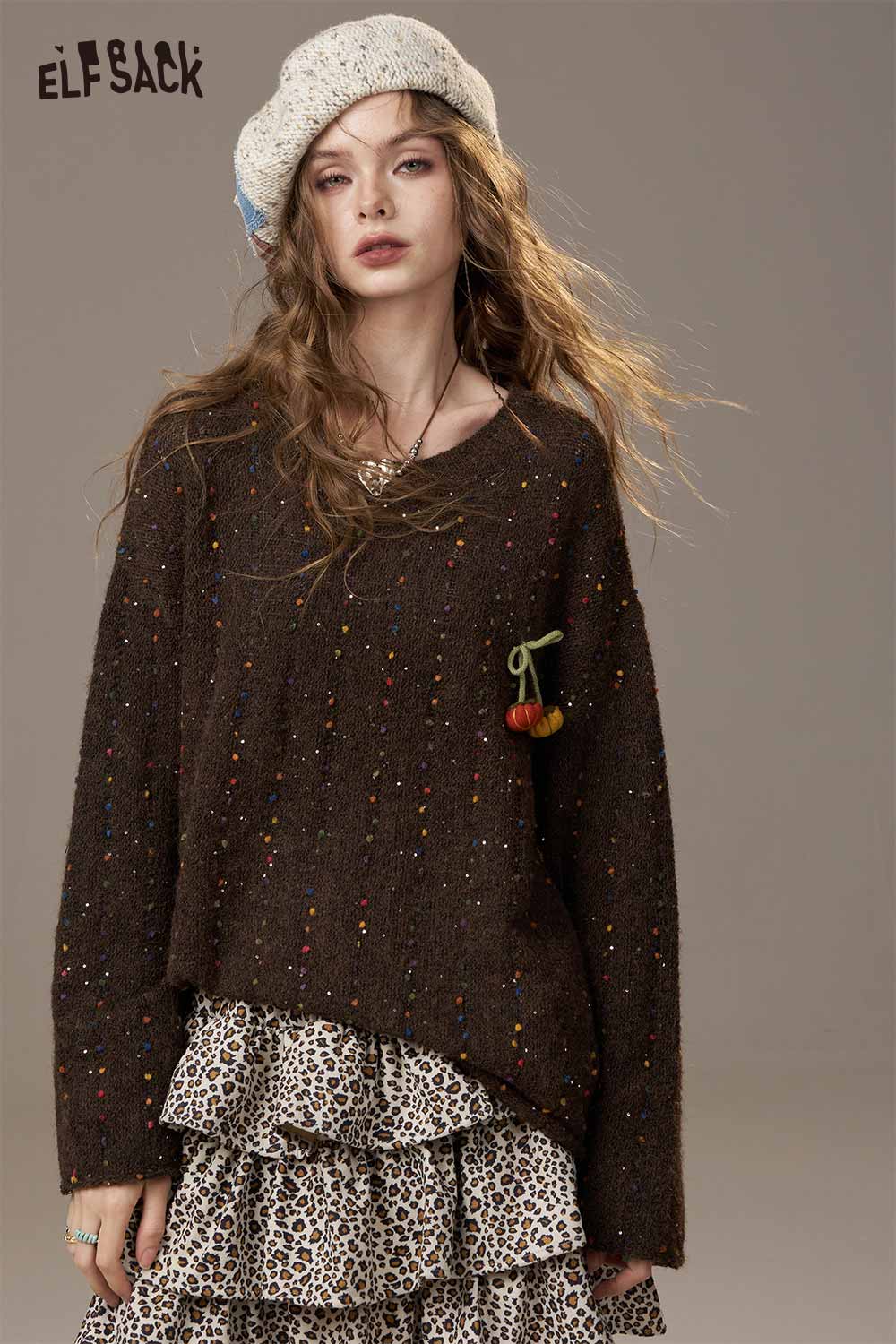 ELFSACK pumpkin motif knit sweater with colorful accents, stylishly paired with a layered skirt