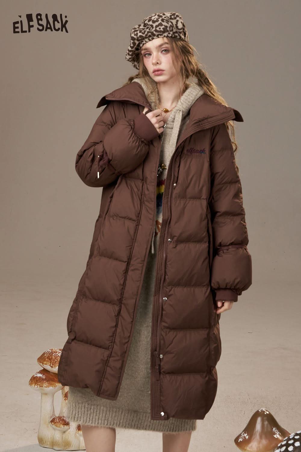ELFSACK model wearing a stylish rainbow cartoon sweater dress under a cozy brown puffer coat
