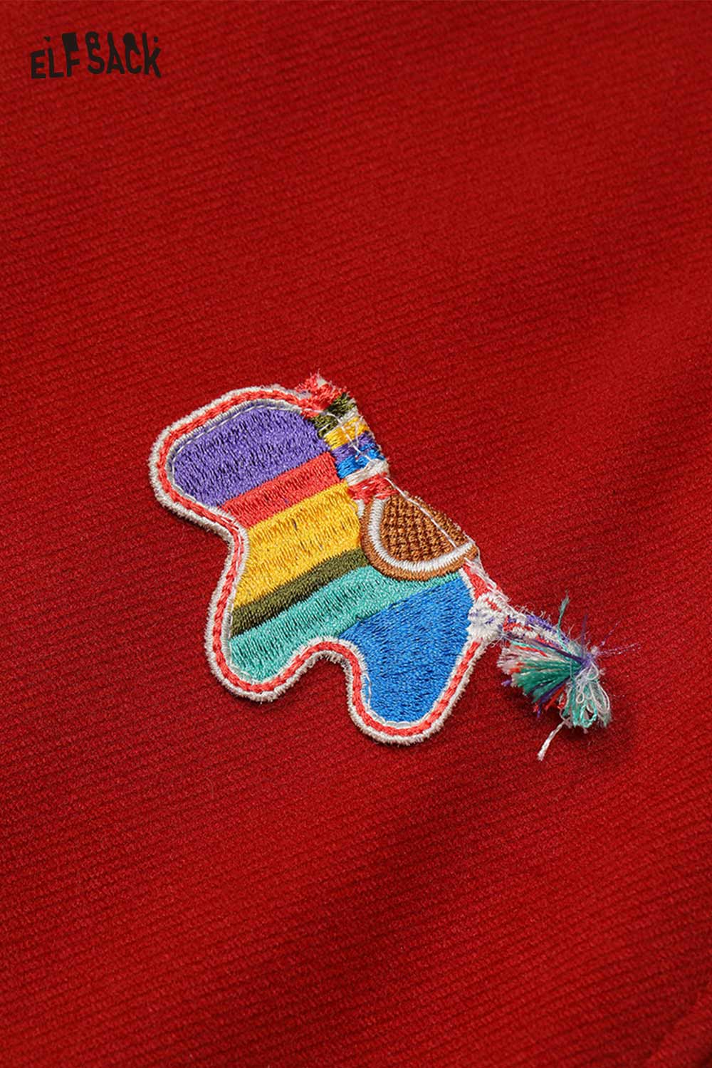 Close-up of red wide leg pants for women with colorful embroidered patch detail