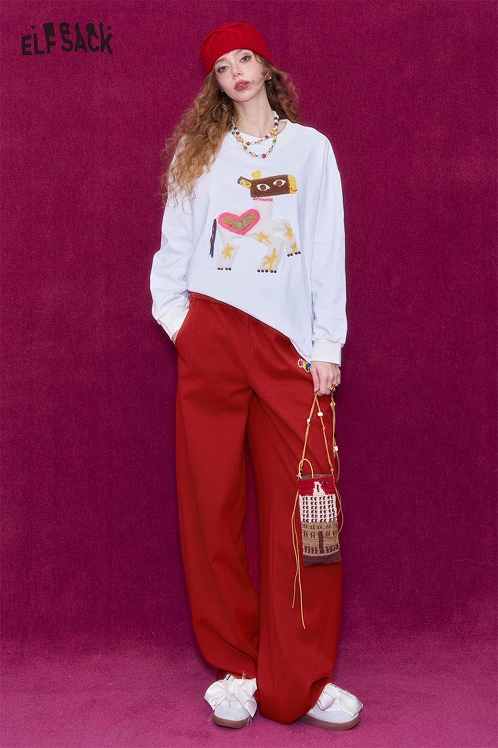 Woman wearing ELFSACK red wide leg pants for women paired with a graphic sweatshirt and accessories