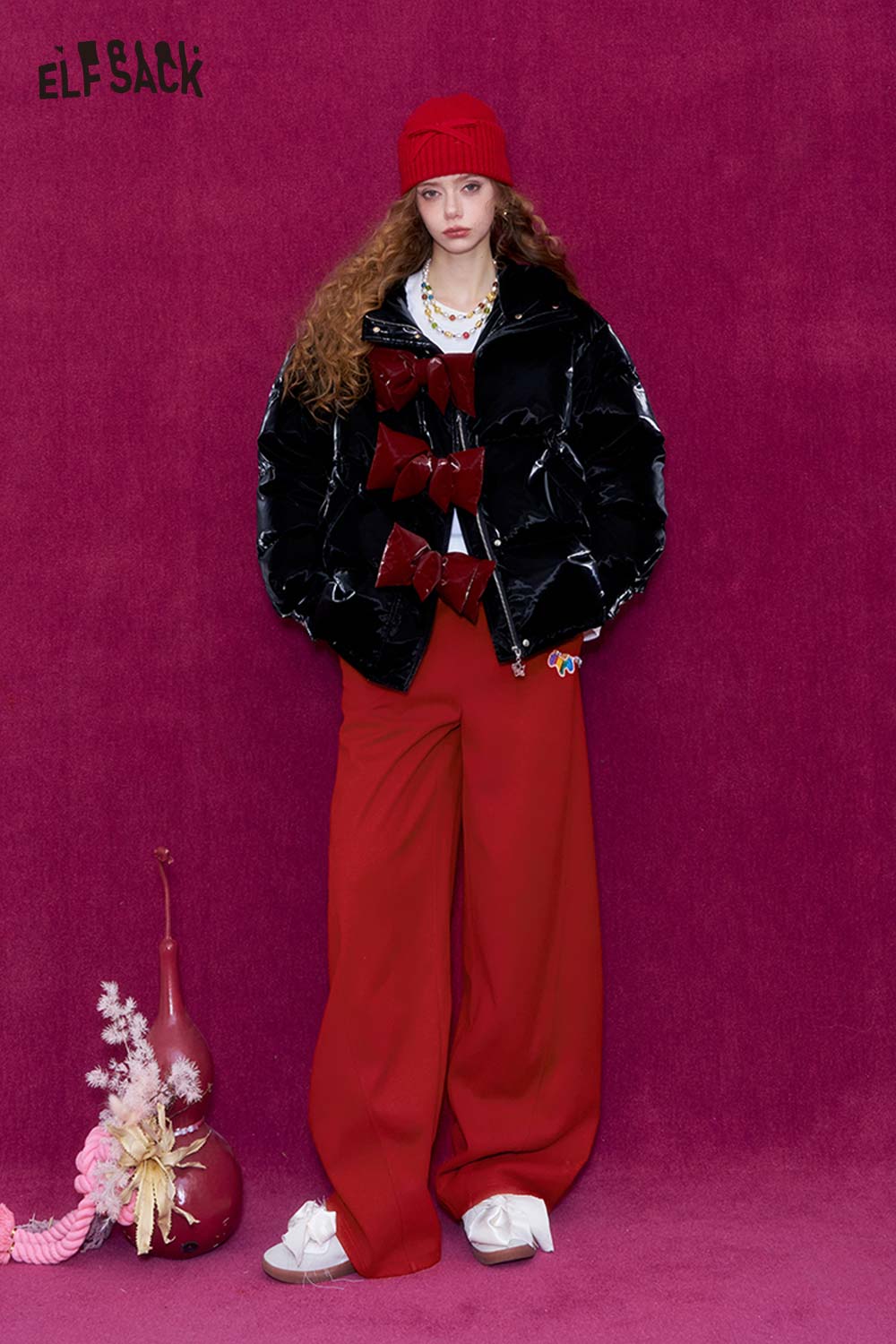 Fashionable woman wearing red wide leg pants for women with a stylish black puffer jacket and accessories