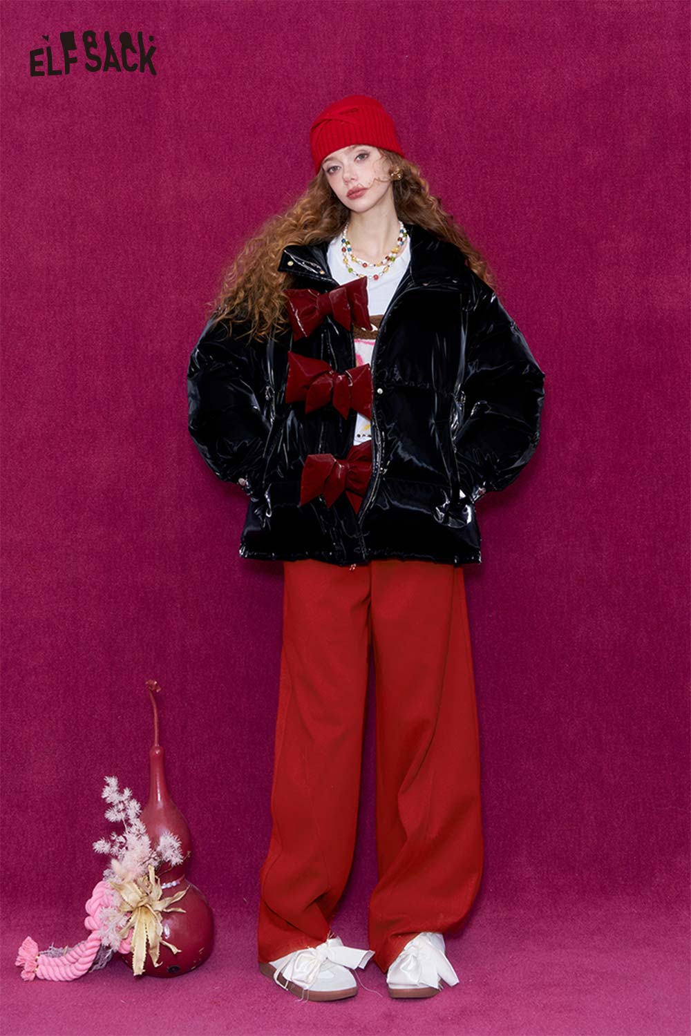 Model wearing red wide leg pants for women paired with a stylish black puffer jacket and accessories