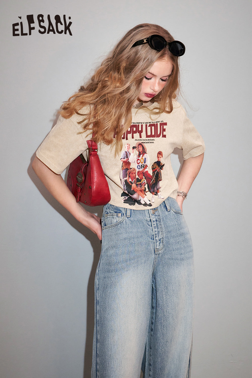 ELFSACK Retro Graphic beige T-shirt with vintage band print worn with light blue jeans and red shoulder bag