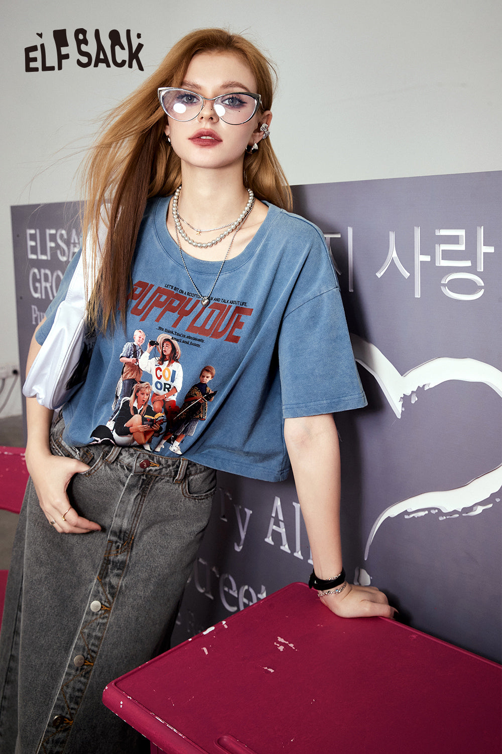 ELFSACK blue Retro Graphic T-shirt with colorful band print worn by woman with glasses