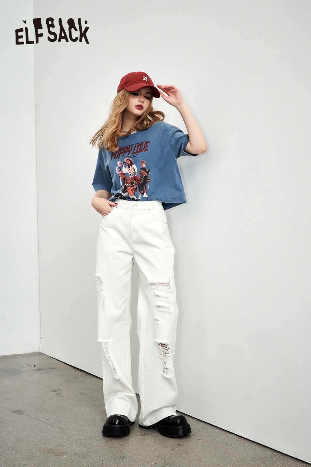 ELFSACK Retro Graphic blue cropped T-shirt styled with white ripped jeans and red cap