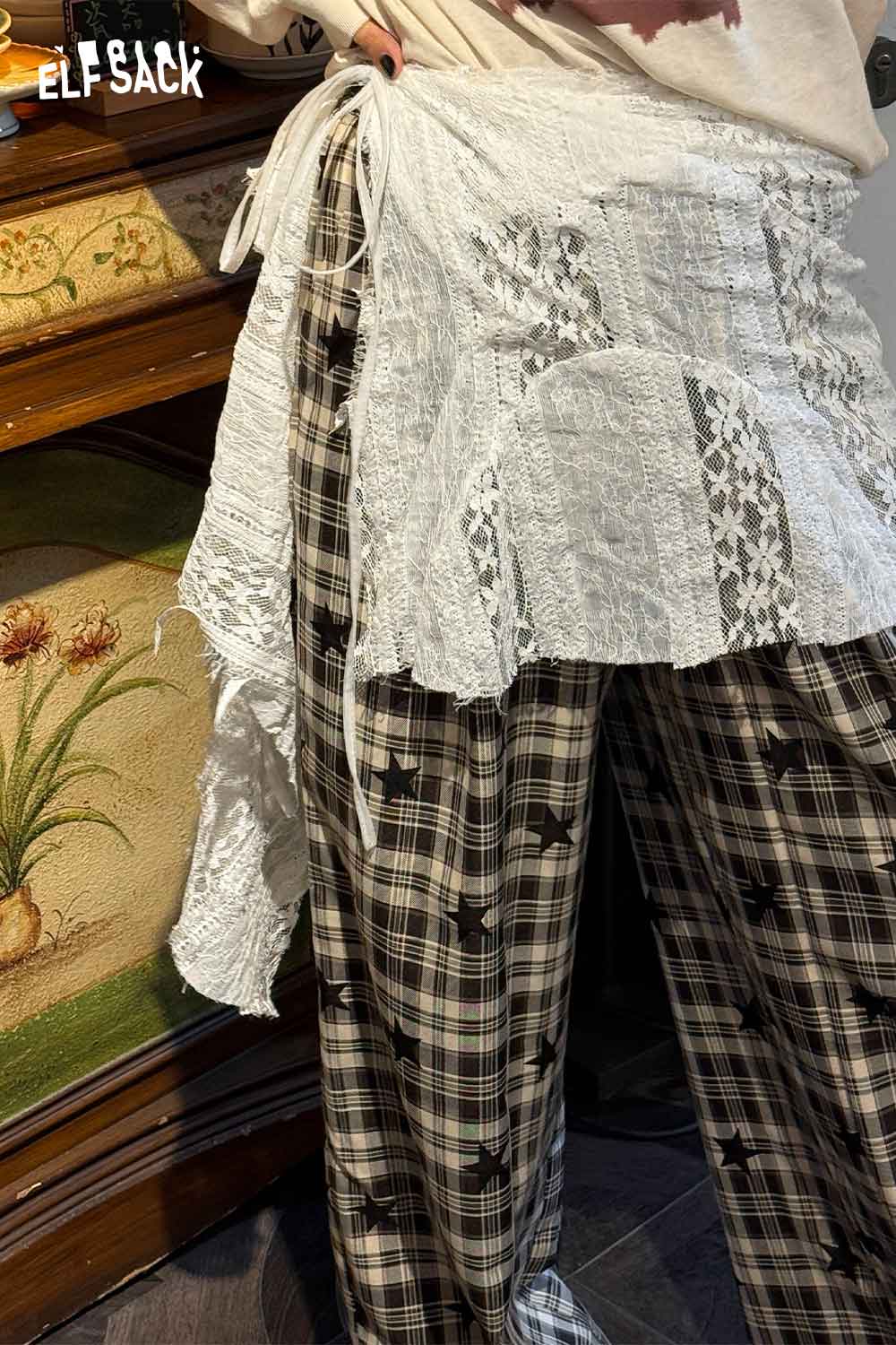 White sheer lace overlay skirt layered over plaid pants for a stylish boho look