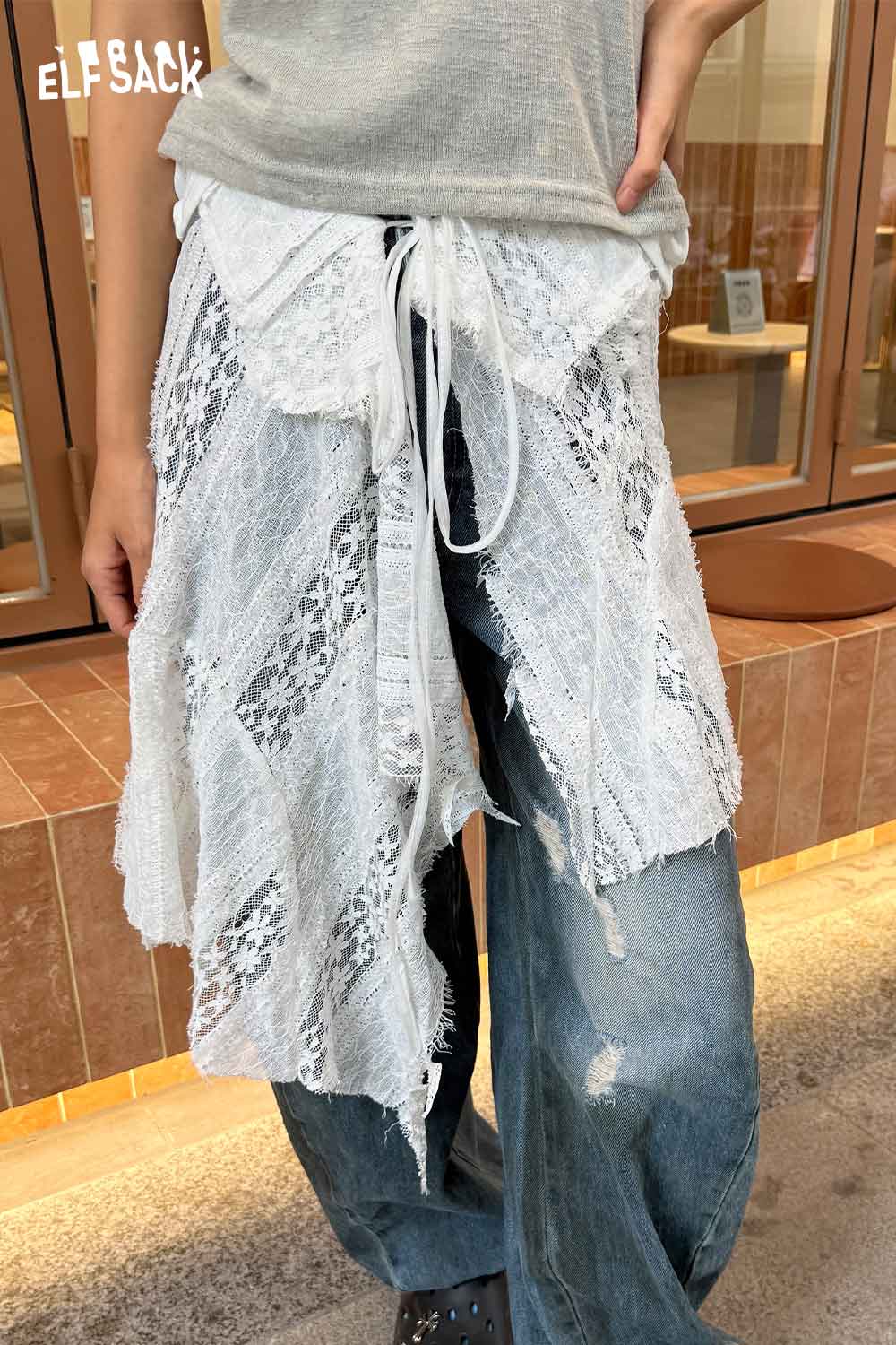 ELFSACK sheer lace overlay skirt styled over casual jeans for a trendy layered look