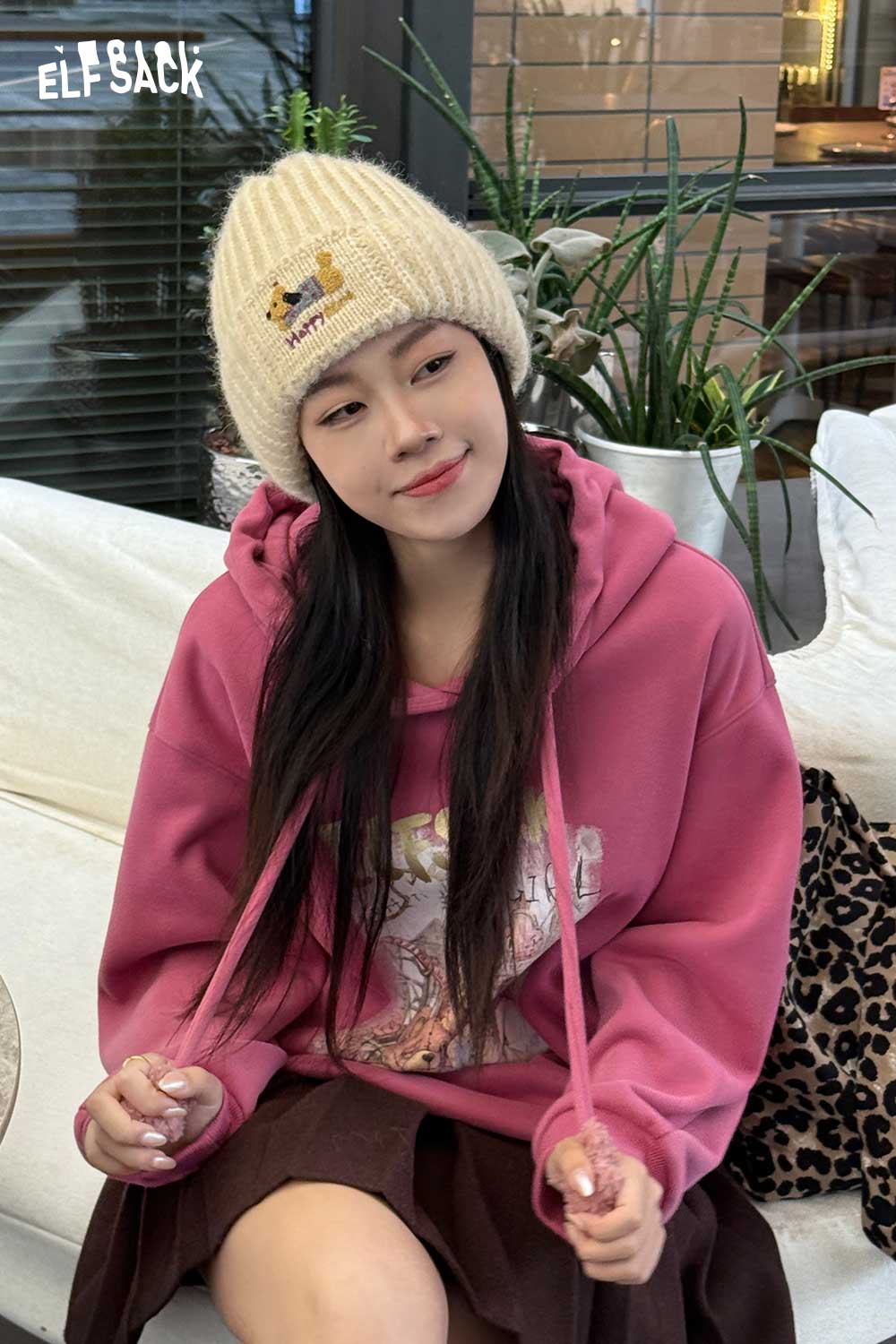 ELFSACK soft dog embroidered hat worn with a pink hoodie and skirt for a stylish casual look