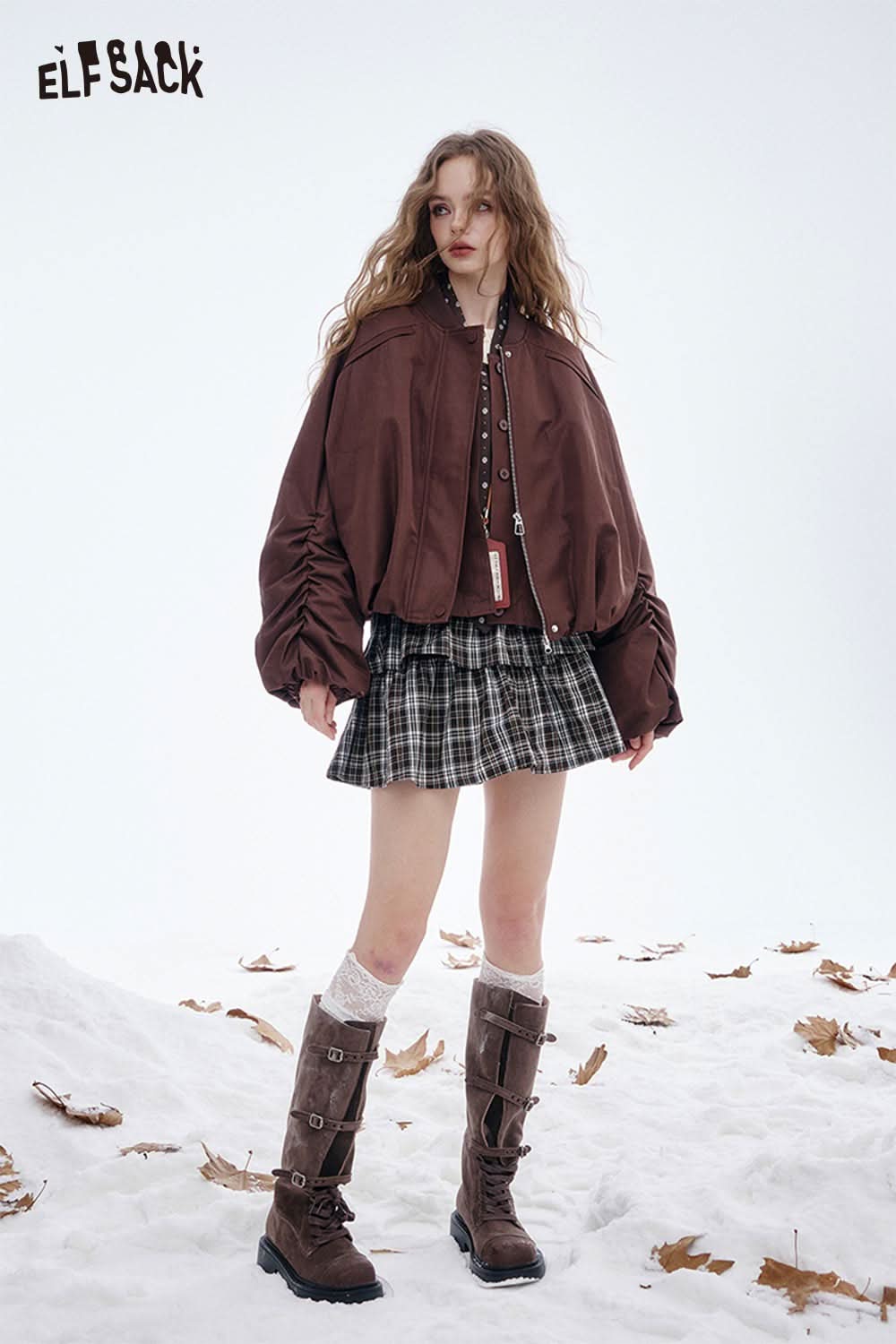 Model wearing a soft embroidered knit sweater paired with a stylish bomber jacket and plaid skirt