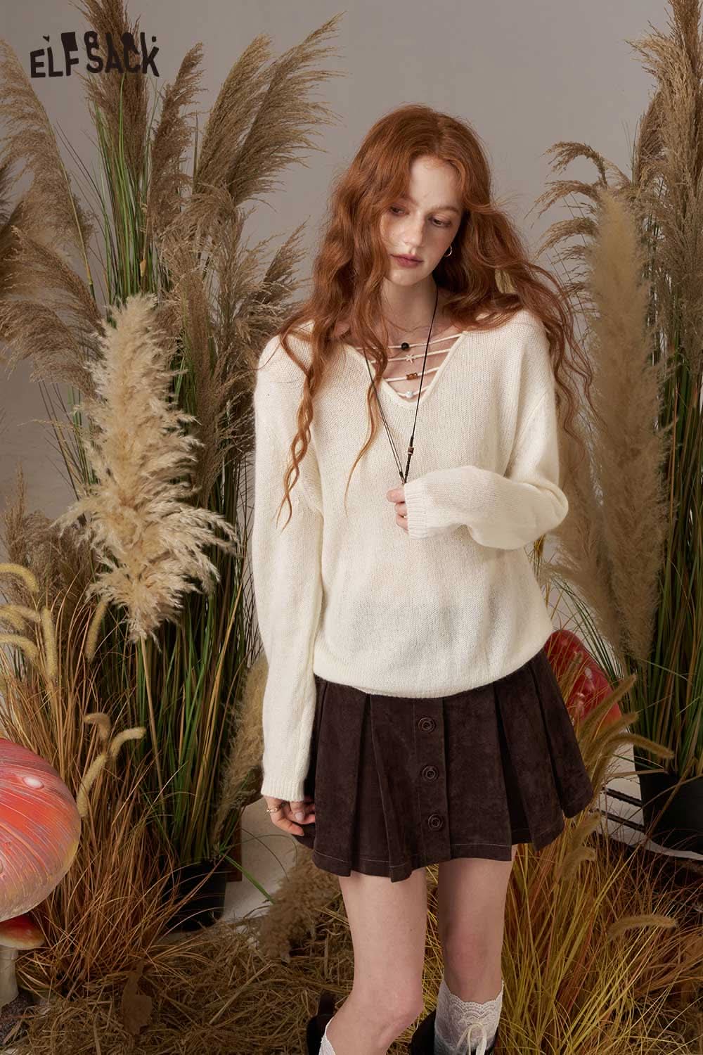 ELFSACK soft knit lace-up sweater in cream paired with a brown skirt for a cozy, stylish look