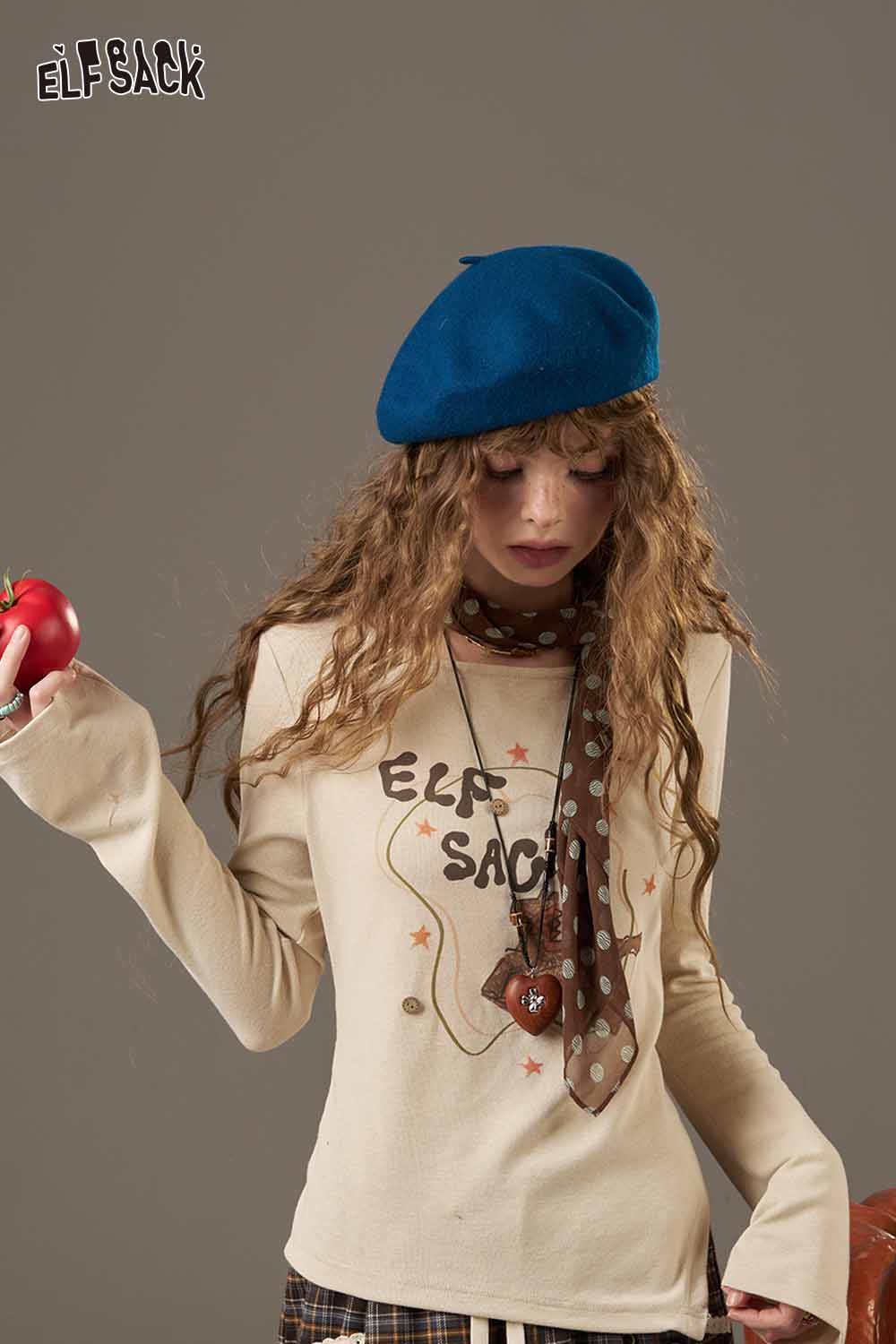 Woman wearing a stylish outfit with a soft pumpkin beanie for women and a patterned scarf
