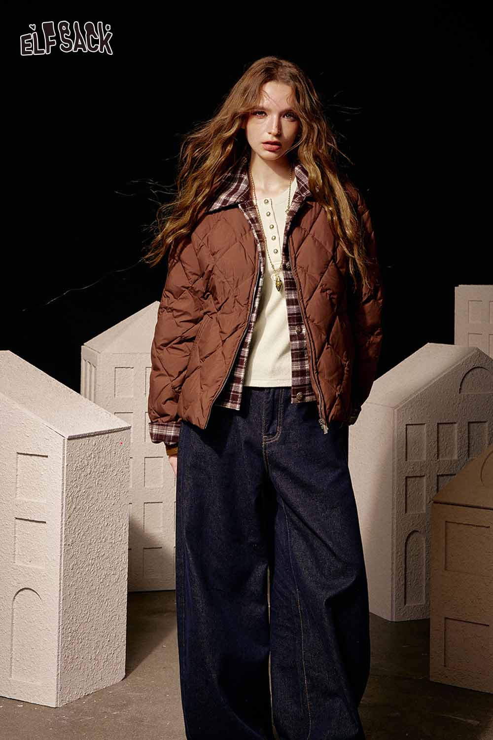 Stylish model wearing a soft spliced sleeve long sleeve tshirt paired with a quilted jacket