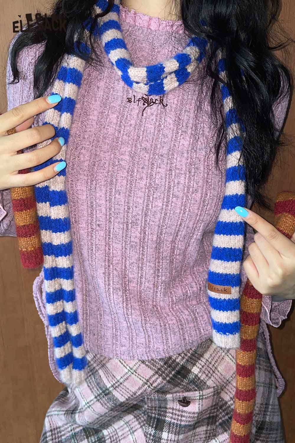 Fashionable soft striped scarf for women in blue and cream, paired with a pink ribbed sweater