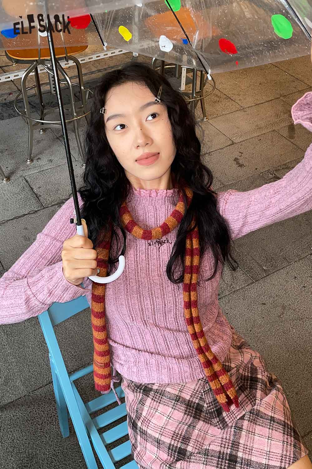 ELFSACK soft striped scarf for women styled with a pink sweater and plaid skirt under an umbrella
