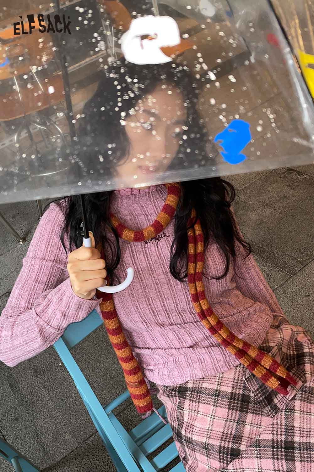 ELFSACK soft striped scarf for women styled with a pink sweater and plaid skirt in a cozy cafe setting