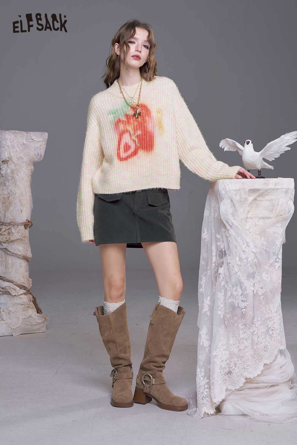 ELFSACK strawberry graphic knit sweater in pastel colors styled with a skirt and knee-high boots