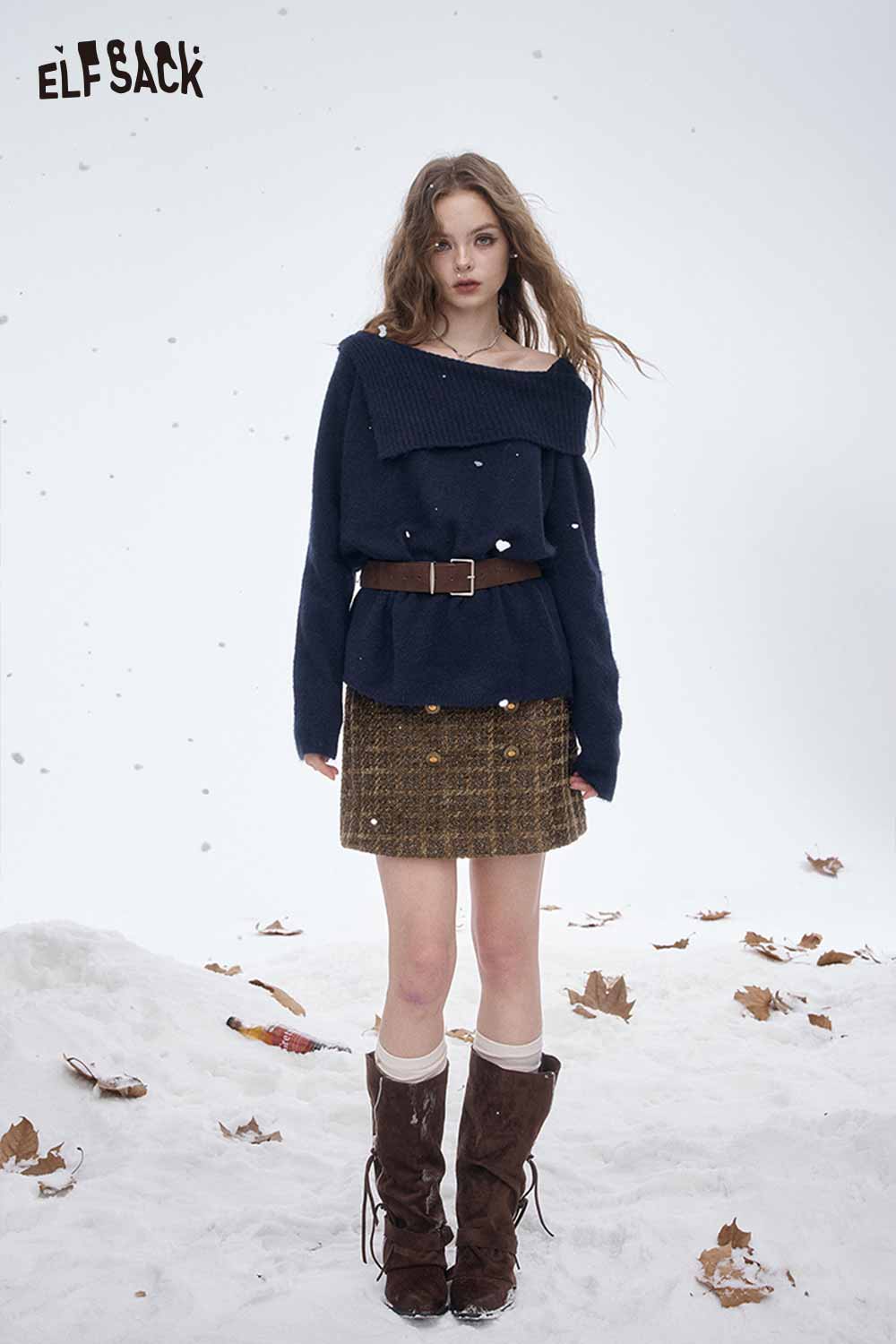 Stylish model wearing a striped gold button A-line skirt paired with a cozy sweater in winter setting