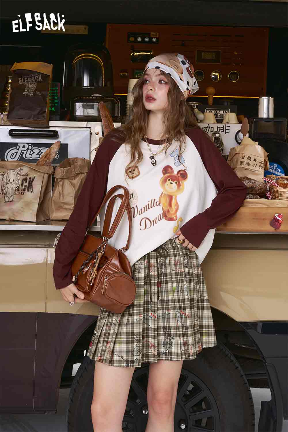 ELFSACK model wearing college style plaid mini skirt pleated green beige plaid styled with raglan top