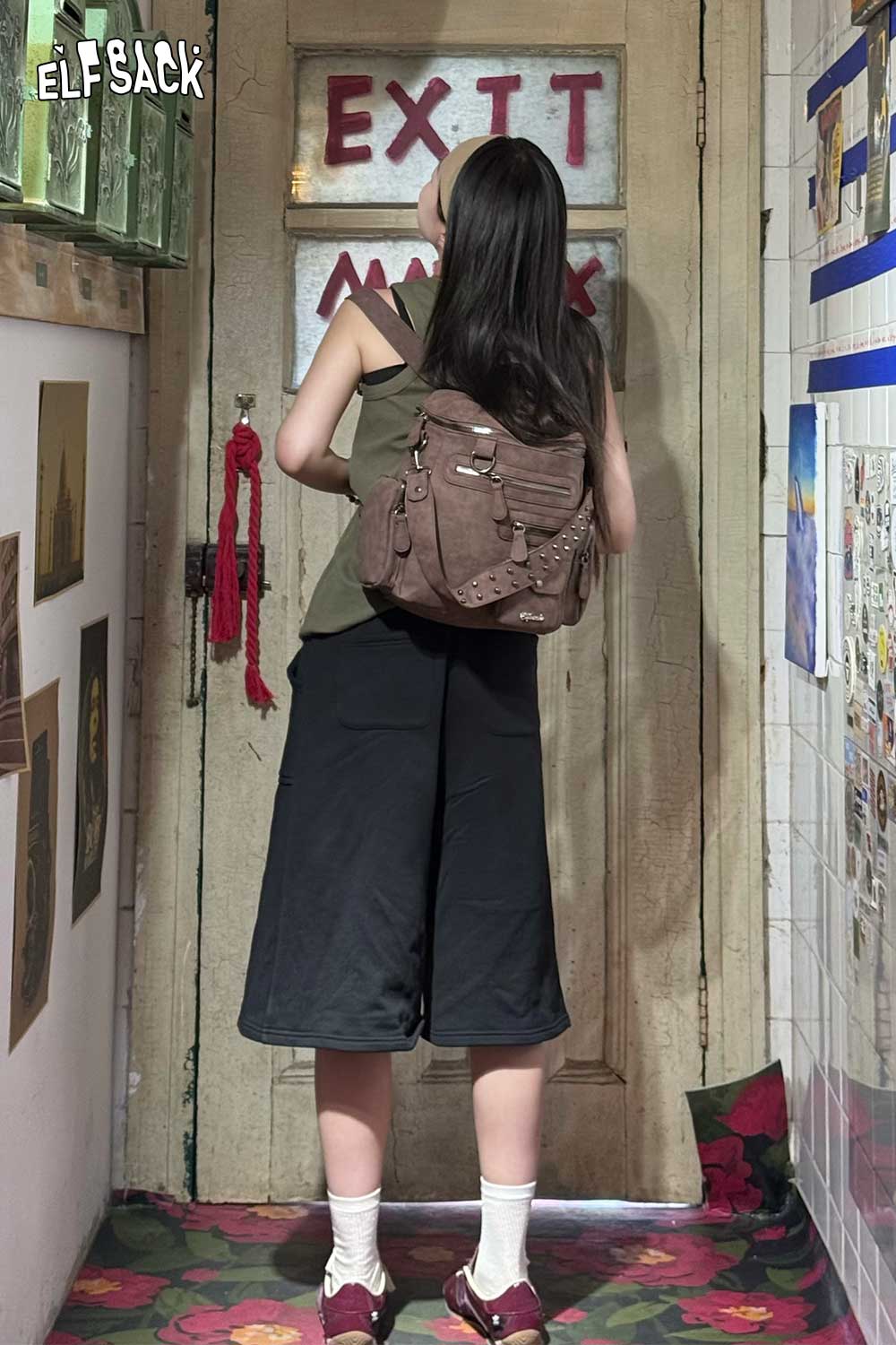 Young woman wearing a suede multi-compartment rucksack in a creative indoor setting