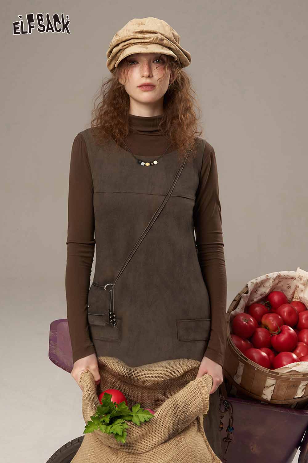ELFSACK suede paneled turtleneck dress in brown, styled with a hat and holding a basket of greens