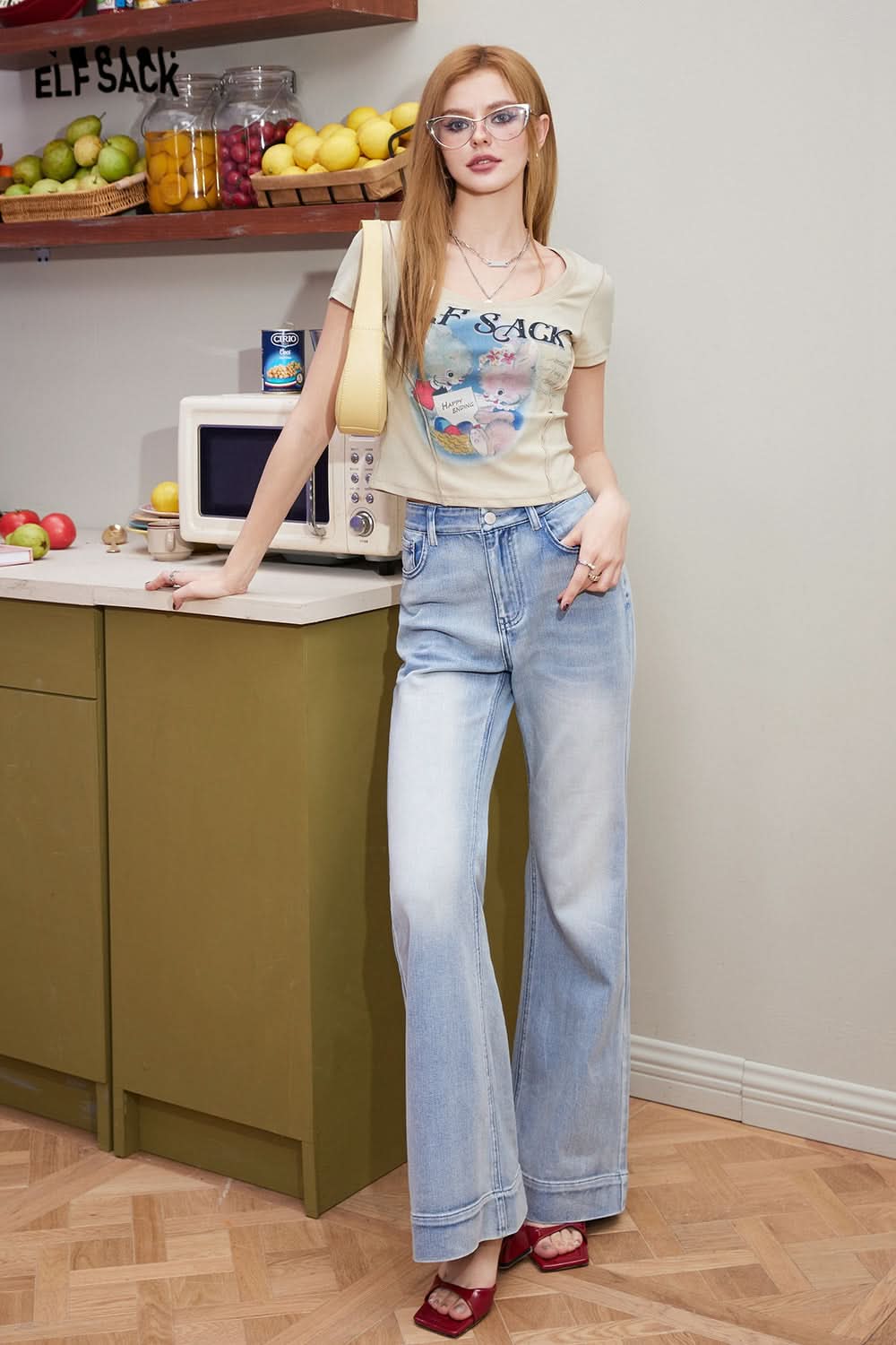 ELFSACK Sweet & Spicy graphic T-shirt worn by woman with light wash wide-leg jeans in kitchen