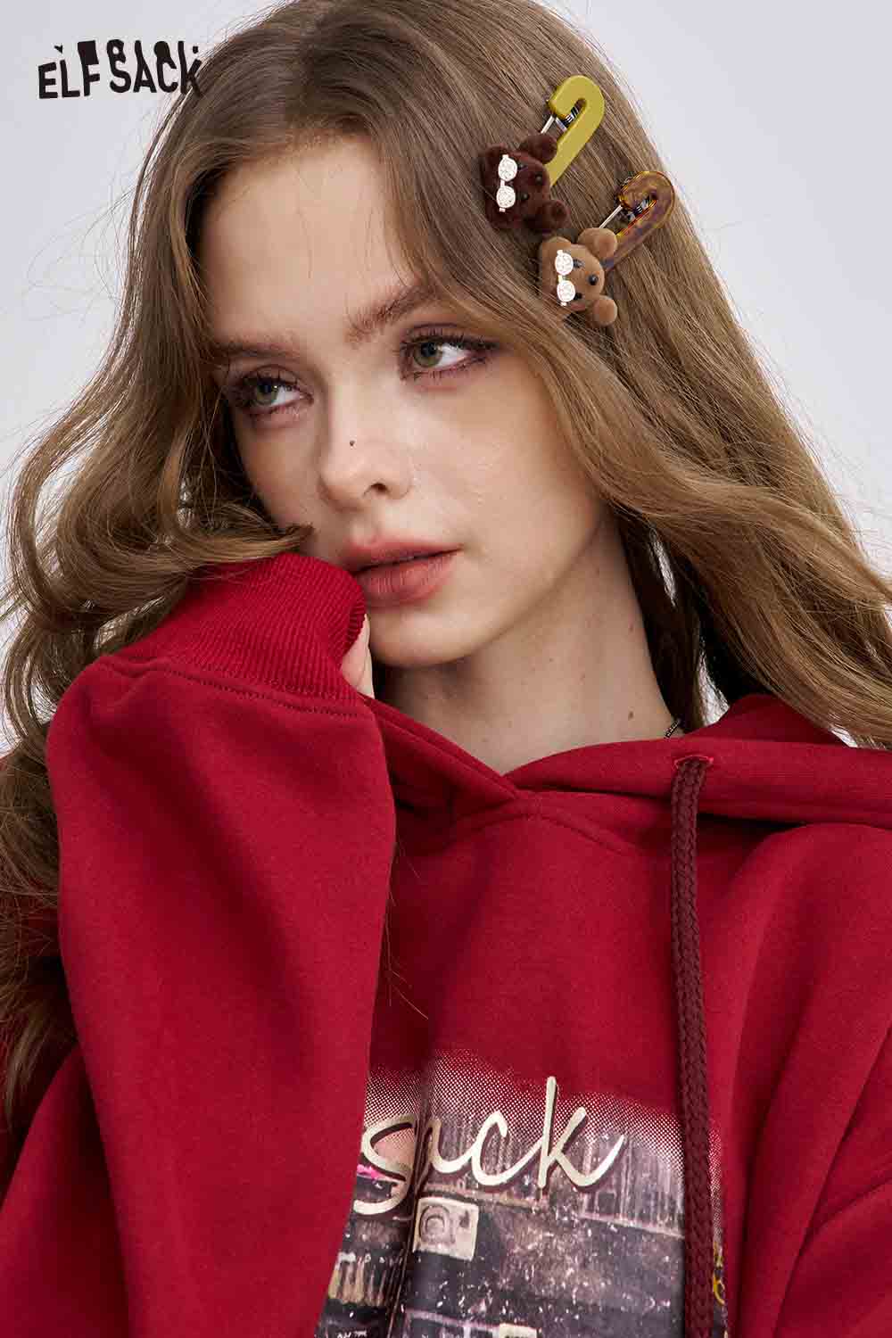 ELFSACK teddy bear hair clips styled in wavy hair with a cozy red hoodie