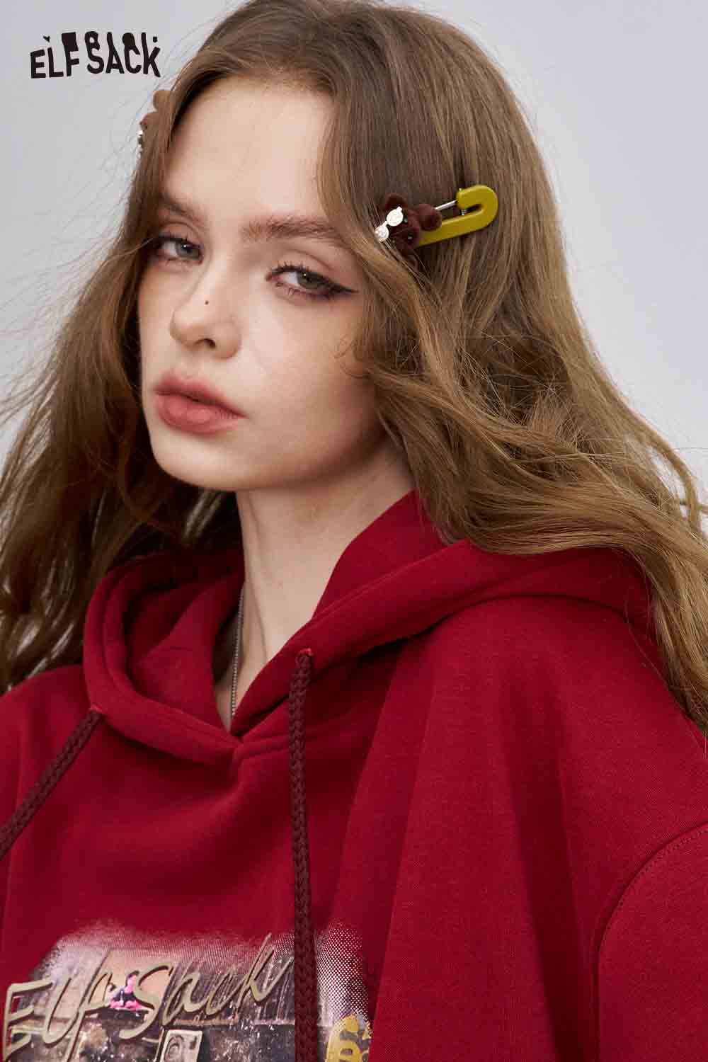ELFSACK teddy bear hair clips styled on long wavy hair with a cozy red hoodie