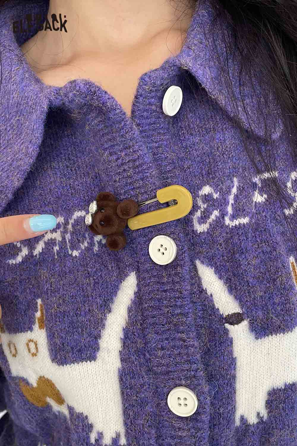 ELFSACK teddy bear hair clips attached to a cozy purple knitted cardigan with button details
