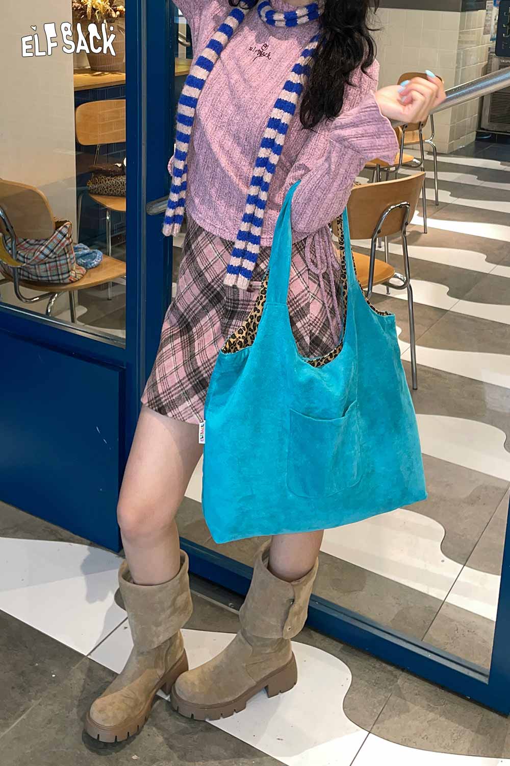 Stylish model showcasing a textured oversized hobo bag in vibrant turquoise with casual outfit