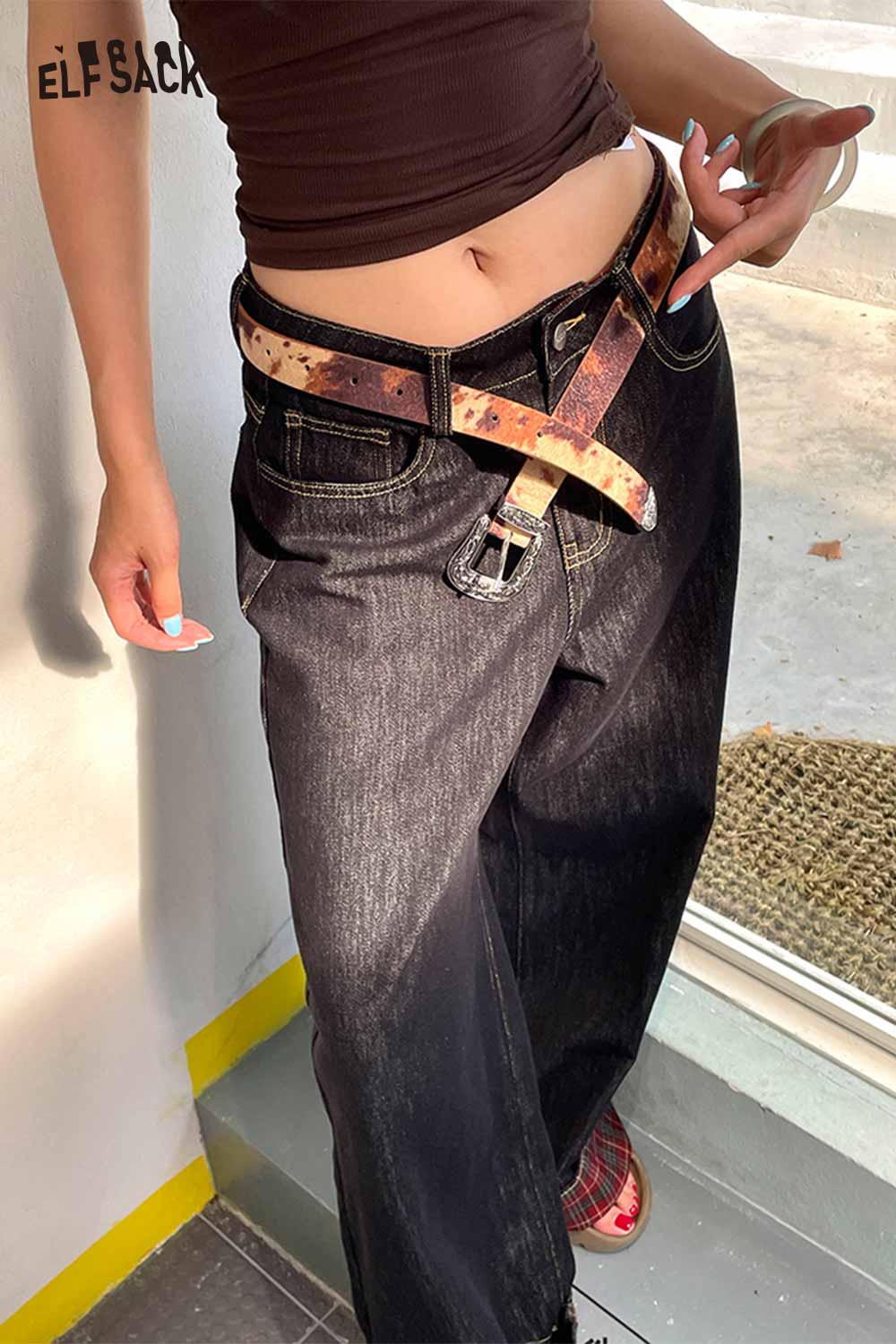 Vegan leather cowhide pattern belt styled with black wide-leg jeans for a trendy outfit