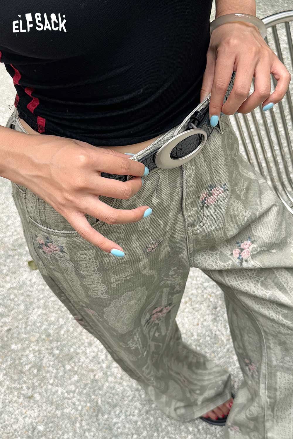 Close-up of a woman wearing a vegan leather croc-embossed belt with stylish floral patterned pants