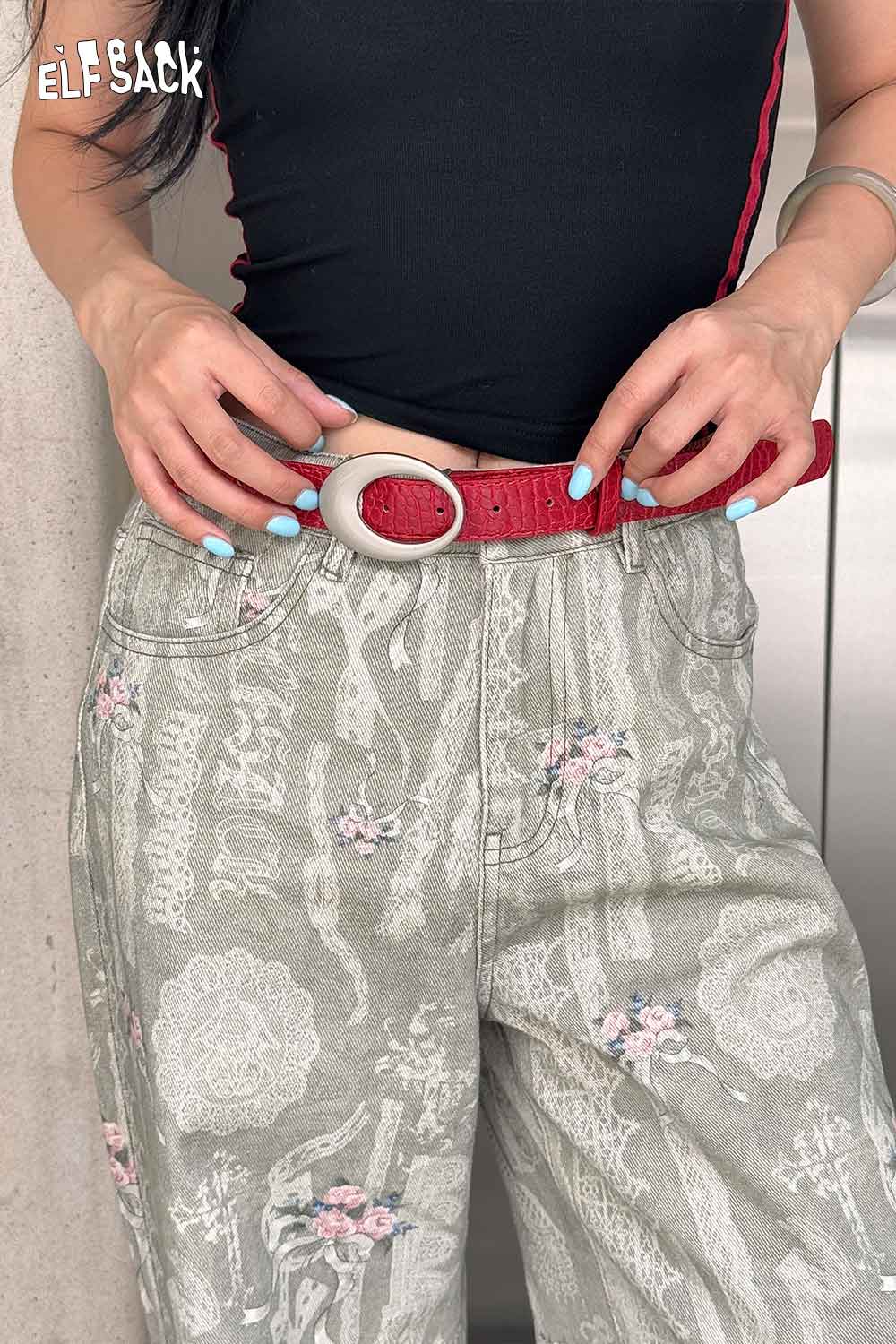 ELFSACK vegan leather croc-embossed belt in red, styled with high-waisted floral jeans
