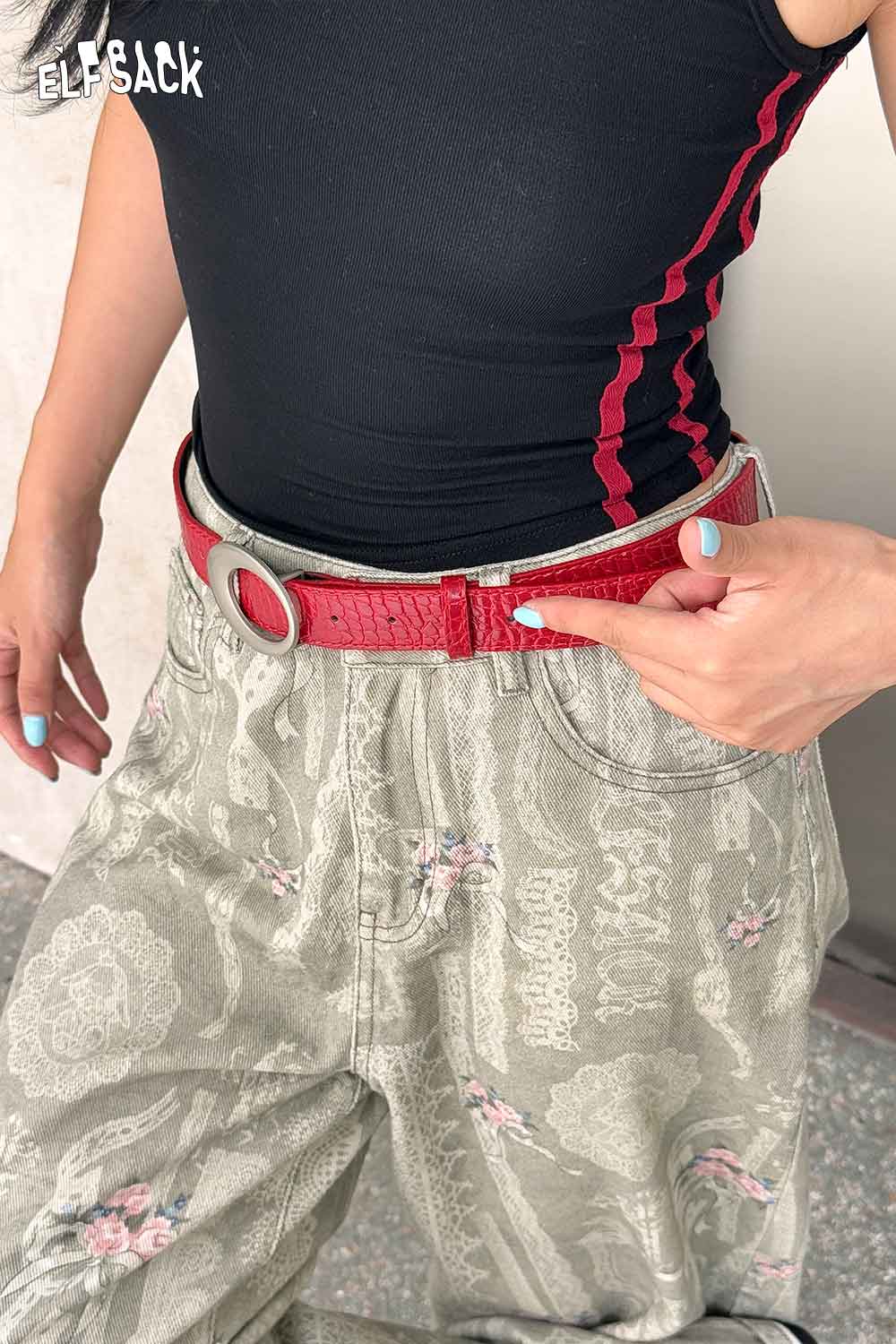 Vegan leather croc-embossed belt in red worn with stylish patterned pants for a trendy look